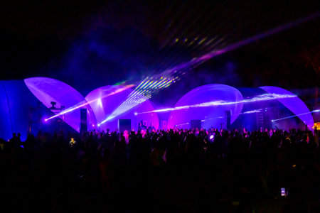 Colorful laser lights shining and moving over dancing crowd during DJ partyの写真素材