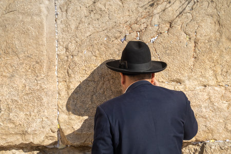 Jewish man in hat facing wall and prayingの写真素材