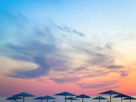 Beach under colorful sunset sky with black cloudsの写真素材