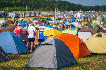 Travelers and camping tents on meadow in countrysideの写真素材
