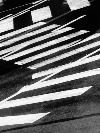 High-contrast black and white image of a zebra crossing, with a focus on patterns and texture.