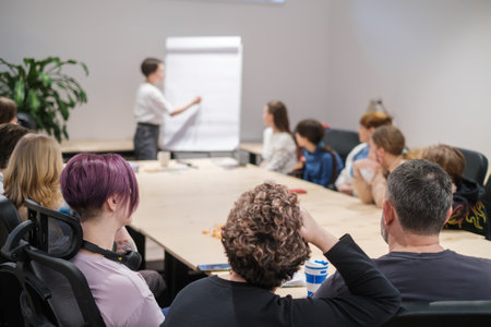 Focused audience at a corporate training session with presenter blurred in the backgroundの写真素材