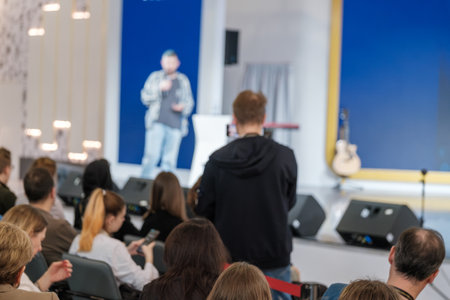 Blurred view of an engaging speaker at a conference with an attentive audience in a seminar hall.の写真素材