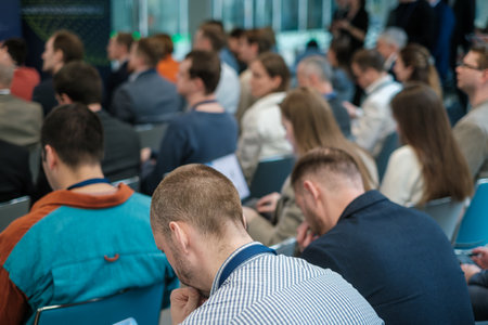 Diverse group of business professionals attentively listening at a conference. Focus on engagement...