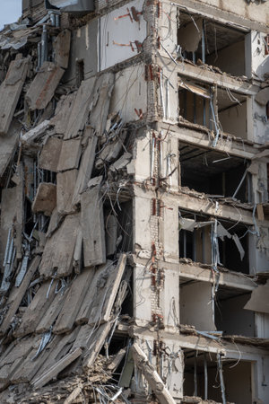 Close-up of a ruined multi-story building with exposed structural elements, depicting urban decay,...
