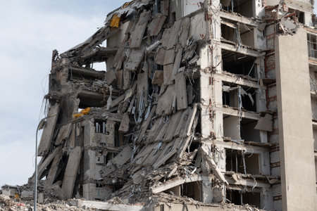 Image of a heavily damaged building with collapsed walls and debris, illustrating destruction and...