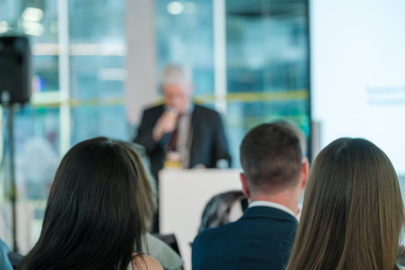 Business conference with a speaker presenting to an attentive audience in a modern office...