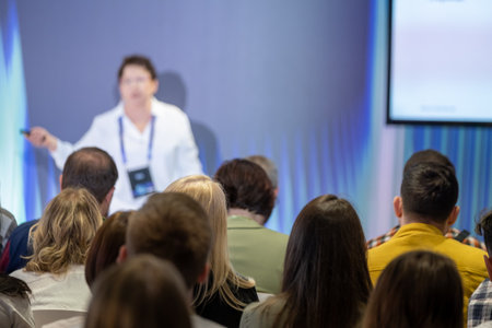 Speaker delivering a presentation to an attentive audience during a business conference in a modern setting.の写真素材
