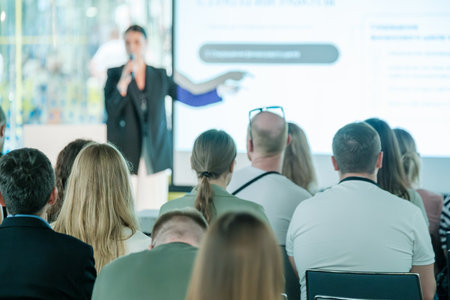 Engaged audience listening to a speaker at a business presentation. Professional setting with diverse audience.の写真素材
