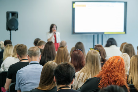 Business professionals attending a seminar and listening to a presentation by a speaker. Concept of learning, corporate training, and professional development.の写真素材