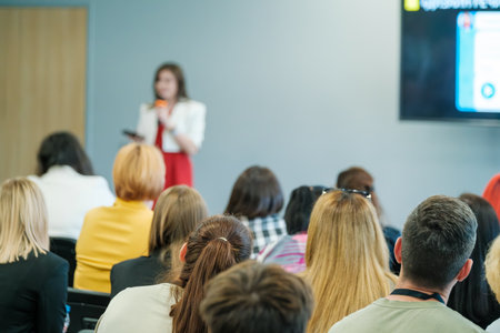 Business meeting seminar with attentive audience listening to a speaker. Professional presentation discussing important topics in a conference room.の写真素材