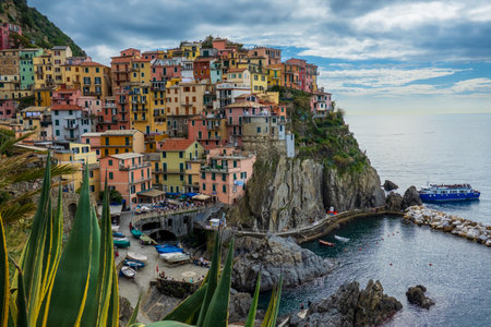 Vibrant buildings sit on cliffs by the ocean in Cinque Terre, offering a picturesque scene. The view...