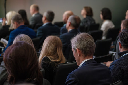 Group of professionals attentively listening during business seminar, focused on gaining insights and knowledge for career growth.の写真素材