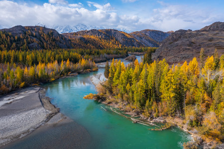 Colorful autumn landscape showing turquoise river flowing through mountainous terrain with golden foliage and surrounding hillsの写真素材
