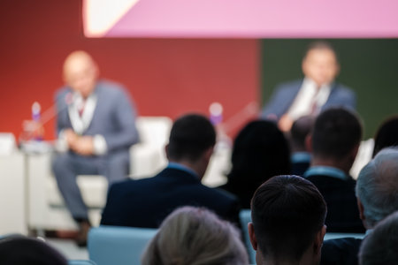 Blurry foreground view highlighting audience attentiveness during professional business conference or seminar.の写真素材