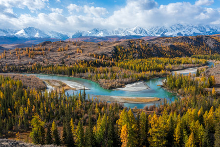 Beautiful autumn scene featuring a winding river amidst colorful forests and distant mountains. The serene landscape showcases natures beauty during the fall season.の写真素材
