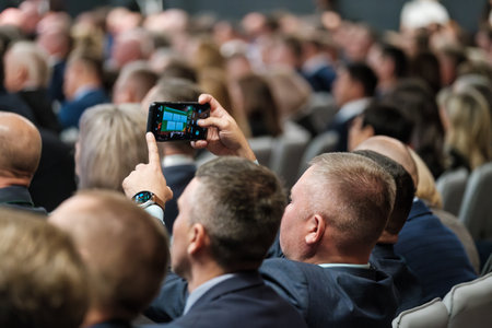 Audience attending a business event, with a focus on participation and information sharing.