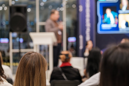 Attendees focus on speaker during a corporate conference in a modern setting. Engaging atmosphere fosters knowledge sharing and networking among professionals Ideal for business and educational themesの写真素材