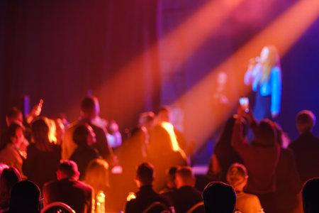 Vividly lit audience gathering at live music event with warm tones and dynamic ambience.の写真素材