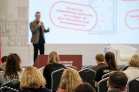 Conference presentation focused on engaging audience as speaker delivers talk with visuals on screenの写真素材