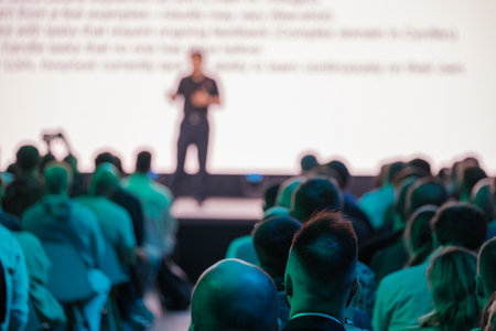 Audience members seated attentively during a conference presentation. Professional atmosphere captured in the image.の写真素材