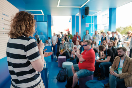 Diverse group attentively listens to a speaker presenting during a public event in an engaging and...