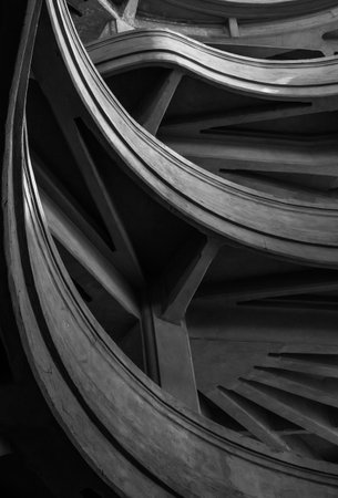 Monochromatic abstract photo of curving geometric architectural structure displaying shadows and patterns.の写真素材