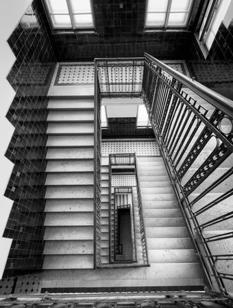 Black and white image of a spiral staircase with symmetrical and geometric design, looking upwards.の写真素材