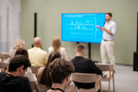 Focused speaker delivers presentation during a professional workshop as audience engages...