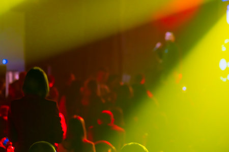 Concert scene with vibrant lighting and silhouettes of audience enjoying a live performanceの写真素材