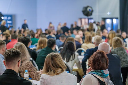 Large audience seated in a conference hall while speakers present. Professional and educational...