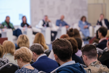 Focused audience listening to a panel of speakers during a professional event discussion