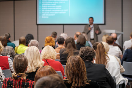 Audience listens to presenter at conference hall with projector screen in background, colorful attendees, business setting, learning atmosphere.の写真素材