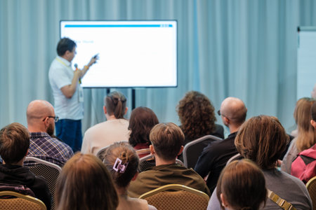 Presenter leads conference with slides as attentive audience engages during session in modern...