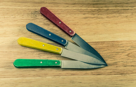 knives on wood, red, yellow, blue, green