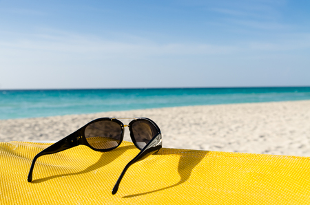 Sunglasses on deckchair, seashoreの写真素材