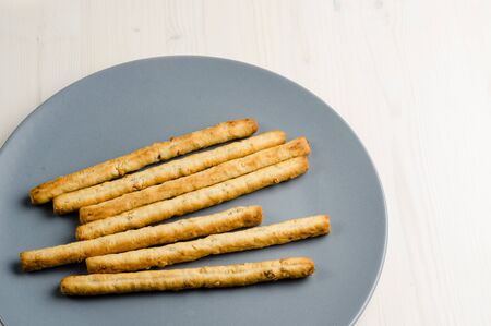 rustic breadsticks in a dish on wood table, close up, backgroundの写真素材