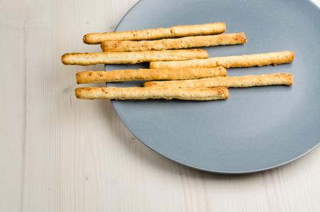rustic breadsticks in a dish on wood table close up background