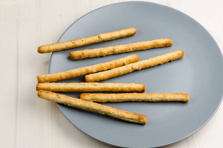 rustic breadsticks in a dish on wood table, close up, backgroundの写真素材