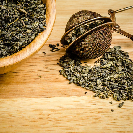 green tea, dried leaves with filter, on wooden background
