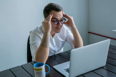 tired young man at work in the officeの写真素材