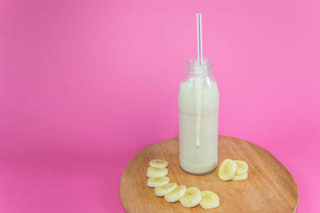 fresh tasty banana smoothie on pink backgroundの写真素材