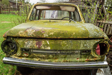 Abandoned Soviet ZAZ 968M car in rust and moss left by some household buildingのeditorial素材