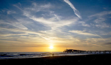 Sunset on the beach with Pier in the background, Tuscany の写真素材
