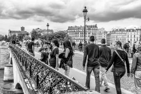PARIS - JUNE 26: Couples have attached padlocks with their names on them to the Pont des Arts bridge, then throwing the key into the Seine river below, as a romantic gesture, June 26, 2013.のeditorial素材