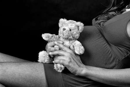Pregnant woman with small taddy bear.の写真素材
