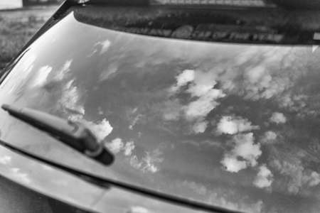 Clouds reflected on the rear glass of a car.の写真素材