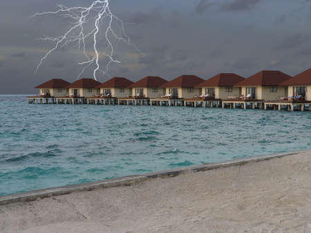 Lightning and black clouds behind the Overwater, Maldives.の写真素材