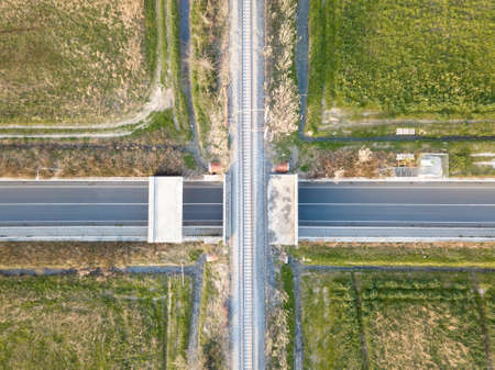 Crossroad between a road and the railway, aerial view from the drone.の写真素材
