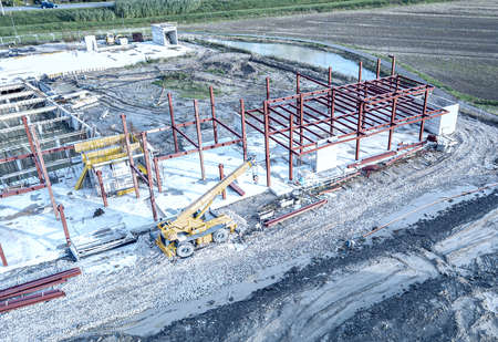 Aerial view of a construction site with heavy machinery for material lifting.の写真素材